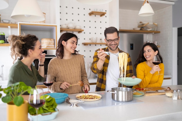 Groep vrienden die maaltijd in de keuken bereiden