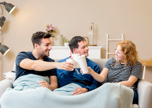 Gratis foto groep vrienden die met soda thuis toejuichen