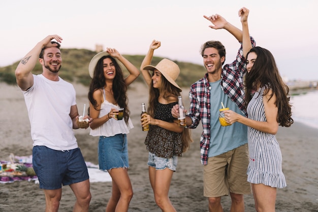 Groep vrienden die op het strand vieren