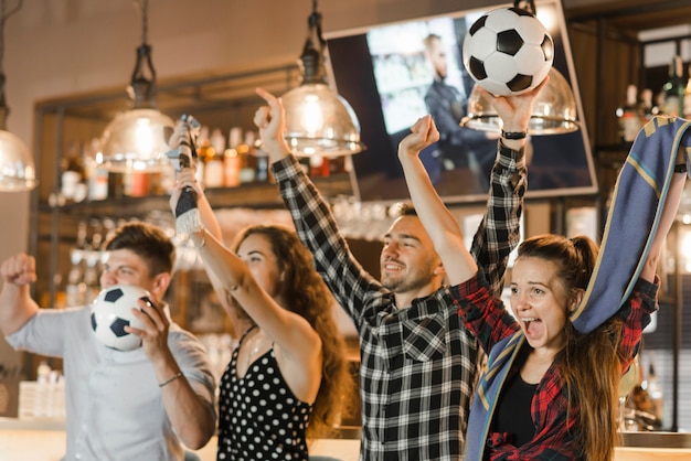 Gratis foto groep vrienden die op sport letten samen vierend overwinning in de bar