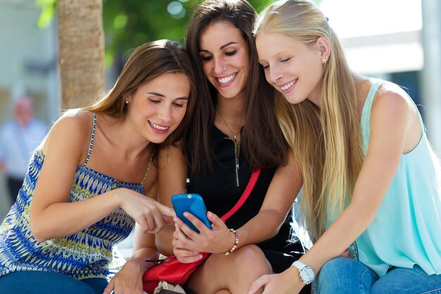 Groep vrienden die plezier hebben met smartphones.