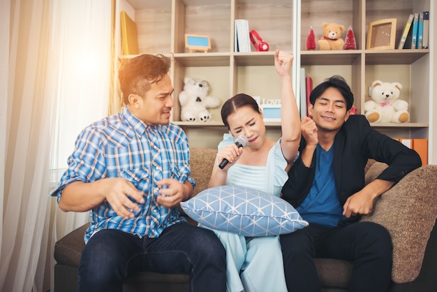 Groep vrienden die pret hebben bij woonkamer die een lied samen zingen