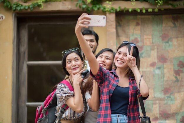 Groep vrienden die selfie in een stedelijke straat nemen die goede pret hebben samen.