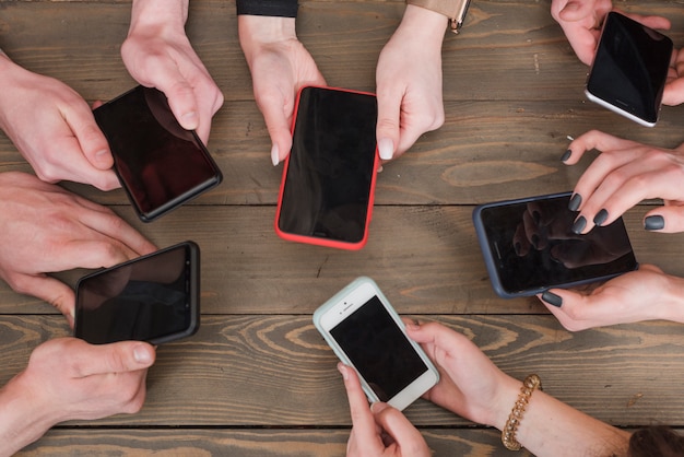 Gratis foto groep vrienden die smartphones gebruiken