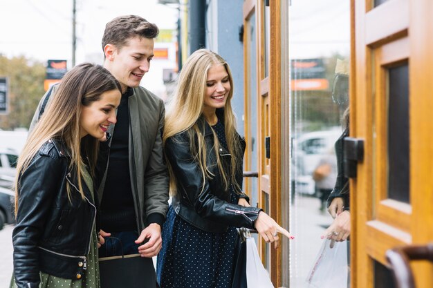 Groep vrienden die van het venster winkelen genieten