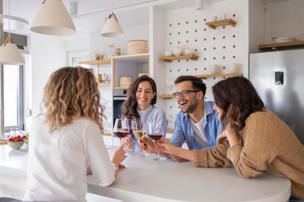 Groep vrienden die wijn drinken in de keuken
