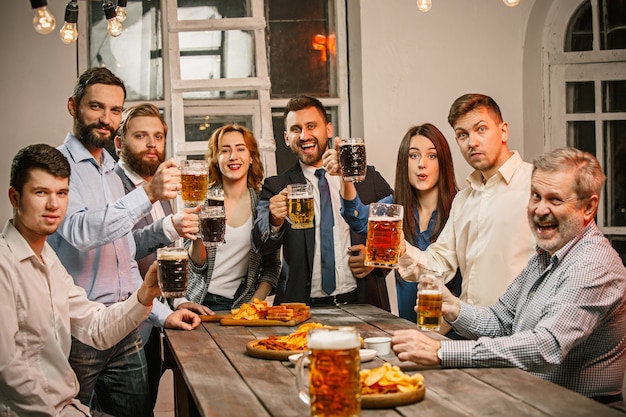 Groep vrienden genieten van avonddrankjes met bier