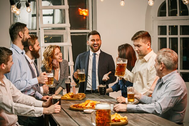 Groep vrienden genieten van avonddrankjes met bier