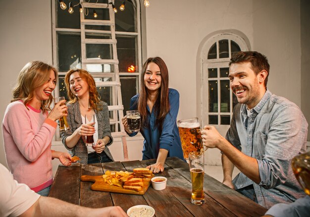 Groep vrienden genieten van avonddrankjes met bier