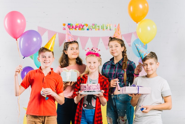 Groep vrienden met de verjaardagscake van de meisjesholding