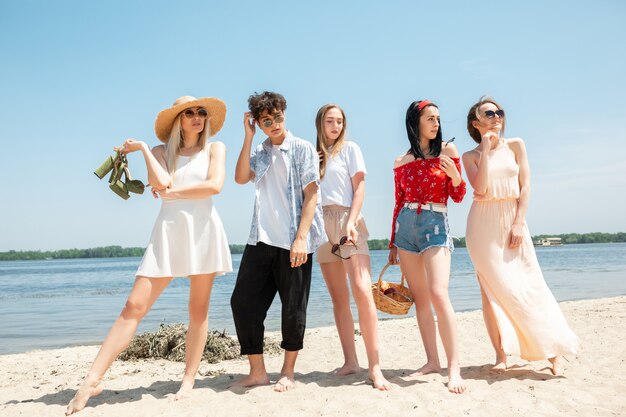 Groep vrienden plezier op het strand in zonnige zomerdag