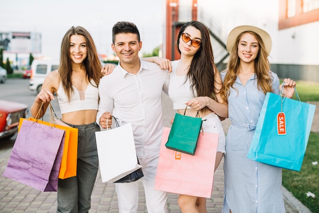 Gratis foto groep vrienden poseren met papieren zakken