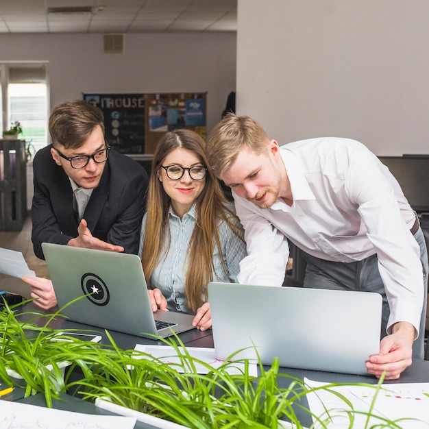 Groep zakenlui die aan laptop in bureau werken