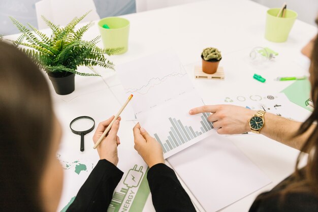 Groep zakenlui die grafiek in bureau analyseren