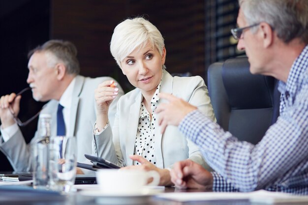 Groep zakenmensen ineengedoken rond tafel aan het werk