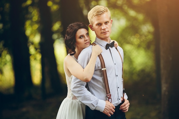 Groom omhelst zachtjes haar bruidegom in het bos