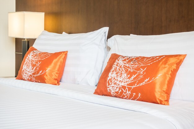 Groot bed met twee oranje kussens