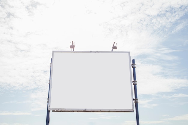 Groot leeg aanplakbord met lamp twee tegen hemel