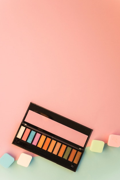 Groot palet van make-up met kleurrijke spons op dubbele achtergrond