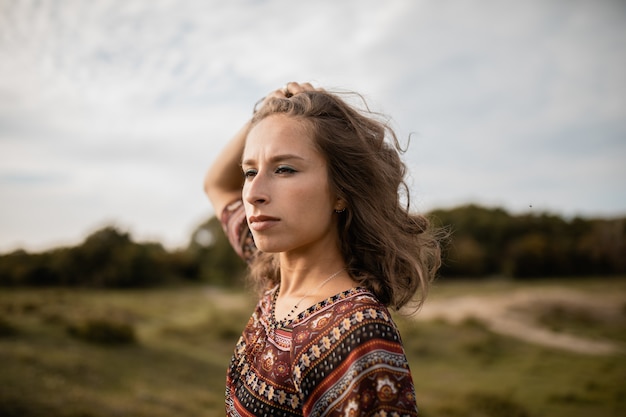 Groothoek opname van een vrouw, omringd door bomen en groen onder een bewolkte hemel