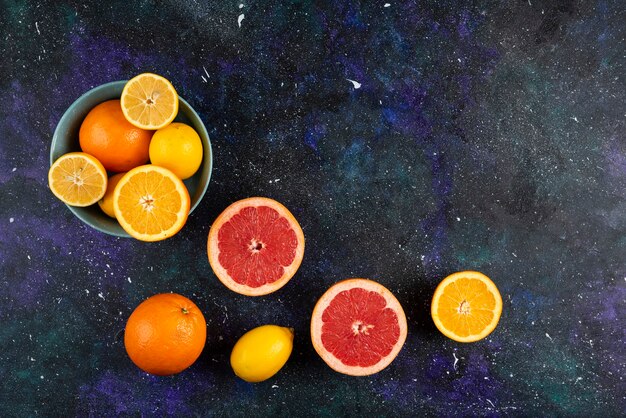 Groothoekfoto van een stapel citrusvruchten, geheel of in plakjes.
