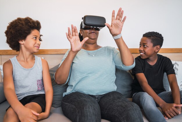 Grootmoeder en kleinkinderen spelen samen met VR-bril.