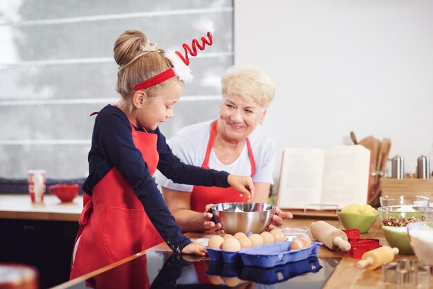 Grootmoeder met meisje bakken in de keuken