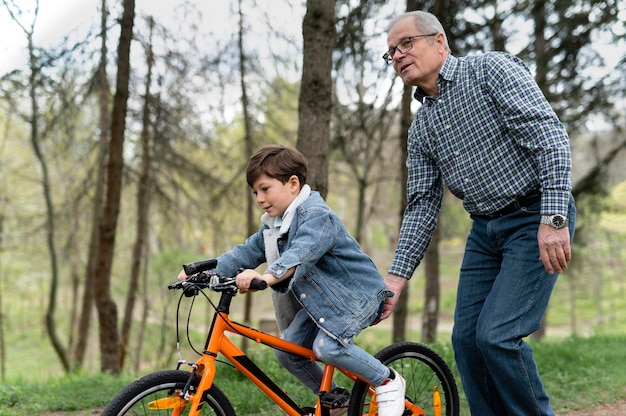 Grootvader die zijn kleinzoon leert fietsen