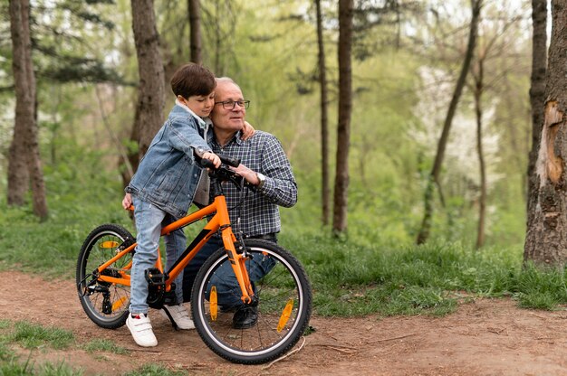 Grootvader die zijn kleinzoon leert fietsen