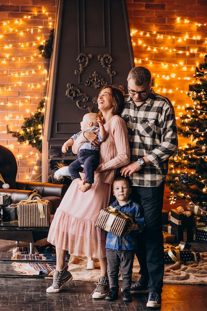 Grote familie op kerstavond met cadeautjes per kerstboom