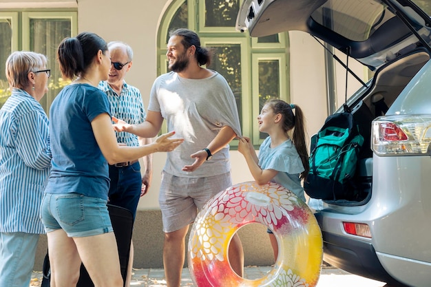 Grote familie vertrekt op vakantie aan zee met autorit, klein kind met grootouders en ouders die in de zomer op vakantiereis reizen. Mensen die enthousiast zijn over de bestemming op zee.