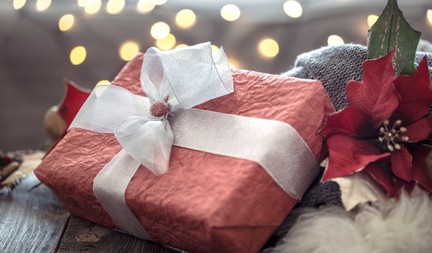 Grote rode aanwezig over Kerstverlichting bokeh in huis op houten tafel. Vakantiedecoratie, magische Kerstmis