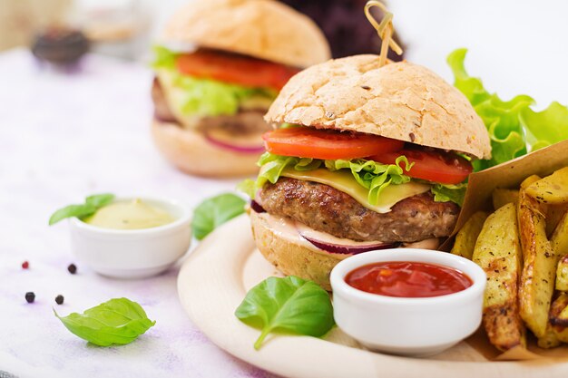 Grote sandwich - hamburger met sappige beef burger, kaas, tomaat en rode ui en frietjes.