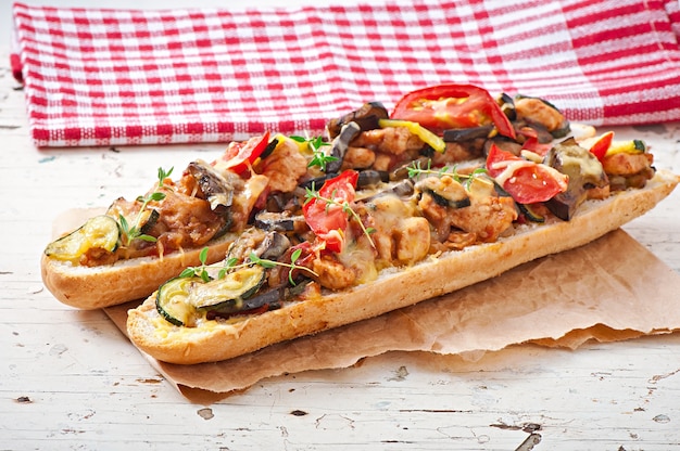 Grote sandwich met geroosterde groenten (courgette, aubergine, tomaten) met kaas en tijm op oude houten achtergrond