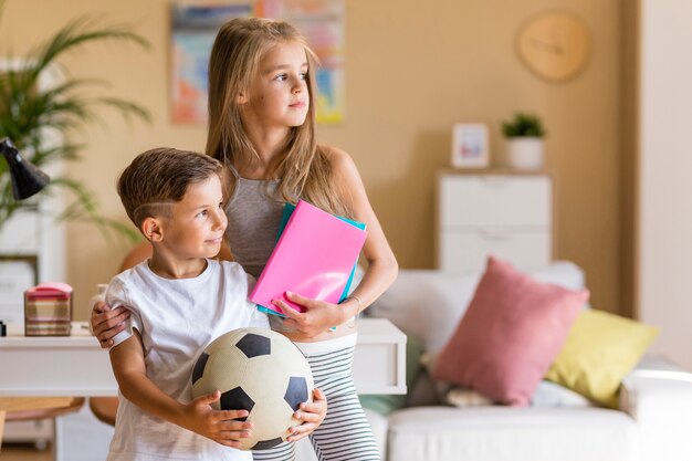 Grote zus die haar kleine broertje in de woonkamer houdt