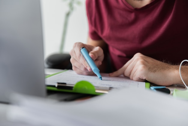 Guy gebruikt een markeerstift op zijn papieren