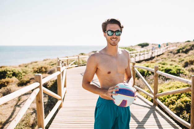 Guy met volleybal op het strand