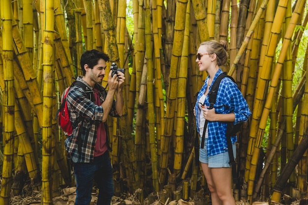 Gratis foto guy neemt foto van vriendin in bamboe bos