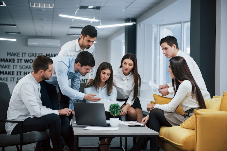 Gratis Foto guy toont document aan een meisje. groep jonge freelancers op kantoor hebben een gesprek en werken