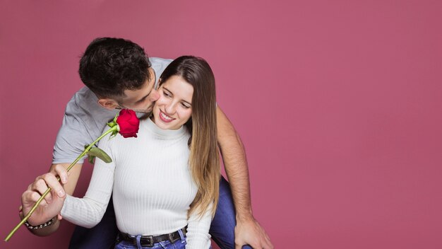 Gratis foto guy zoent en presenteert verse roos tot aantrekkelijke vrolijke dame