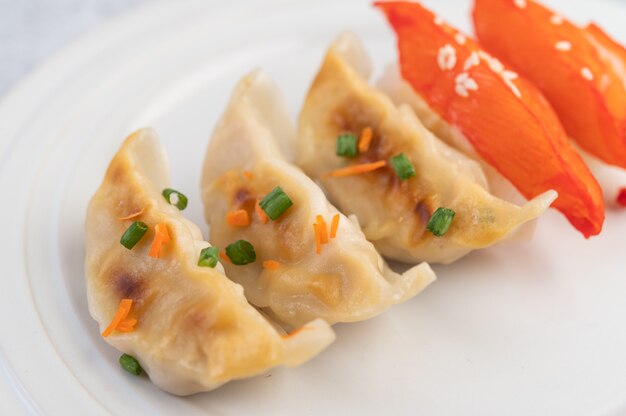 Gyoza in een witte schotel.