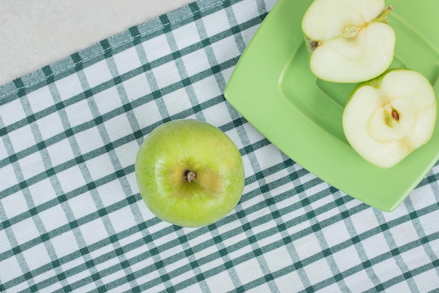 Half gesneden groene appels op groene plaat