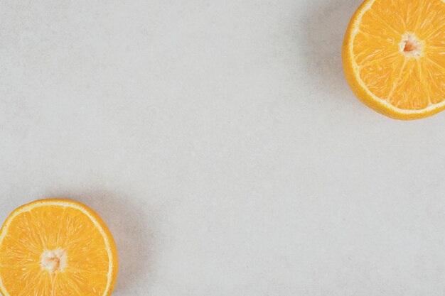 Half gesneden sappige sinaasappel op een grijze ondergrond
