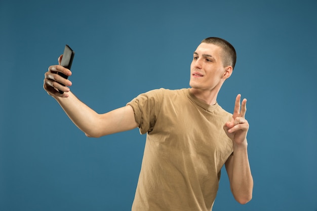 Half-length portret van een blanke jonge man. Mooi mannelijk model in overhemd