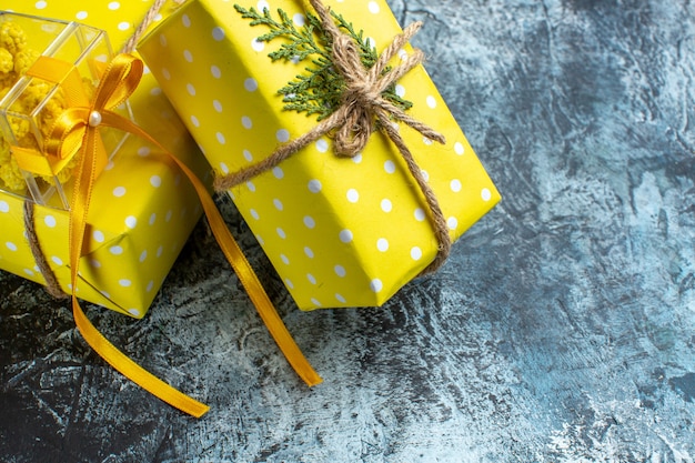 Gratis foto half shot van kerstachtergrond met mooie gele geschenkdozen aan de rechterkant op donkere tafel