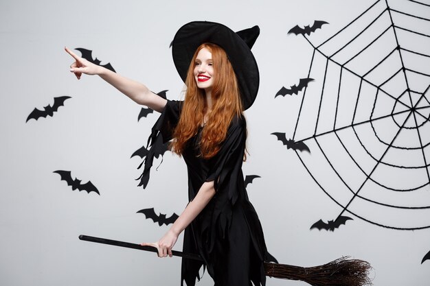 Halloween concept gelukkige elegante heks geniet van spelen met bezemsteel