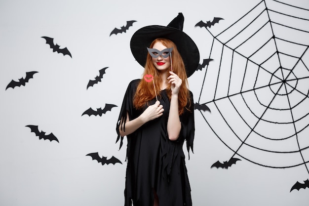 Halloween-concept - mooie meisjes in zwarte heksenjurken met feestrekwisieten.