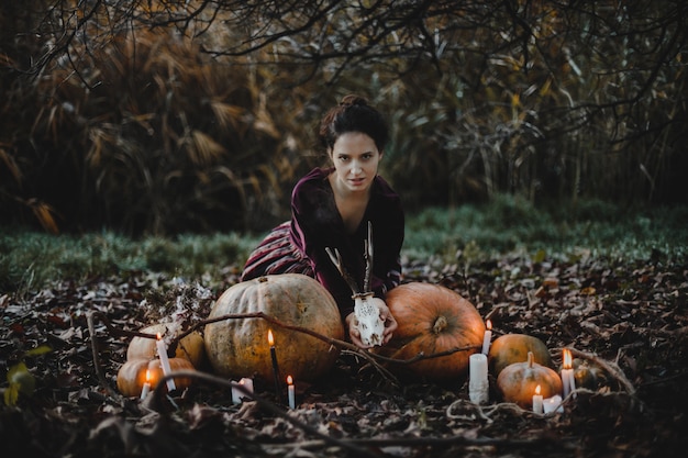 Halloween decor. Vrouw ziet eruit als een heks zit