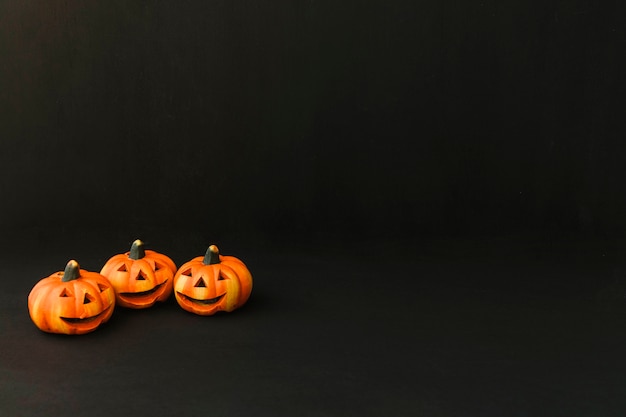 Gratis foto halloween decoratie met drie pompoenen en ruimte