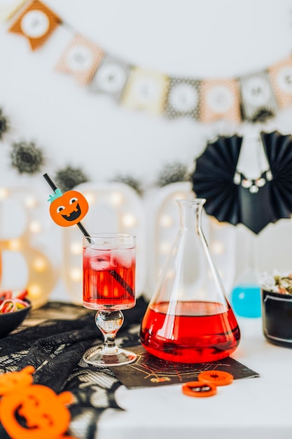 Halloween-decoratie met een rood drankje in een glas en een fles